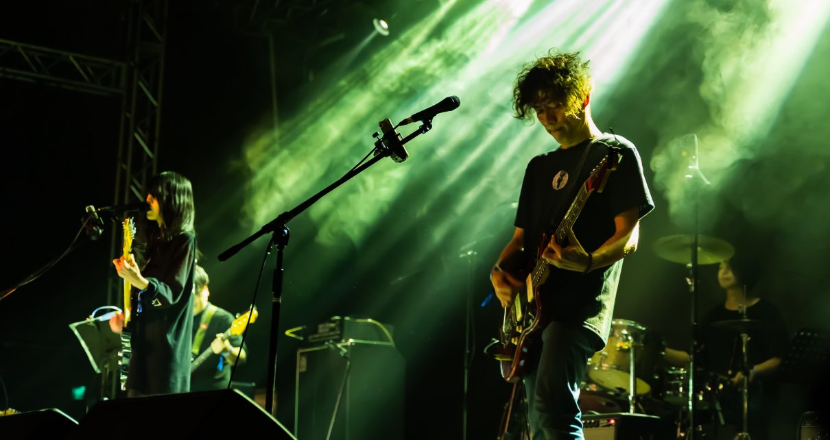man in black crew neck t-shirt playing guitar on stage