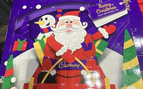 The image shows a Dairy Milk chocolate advent calendar with a picture of Santa on his sleigh and a snowman on the front. with an image