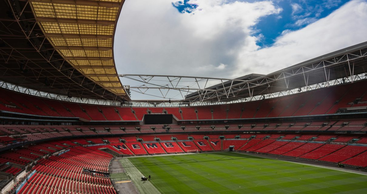 a large stadium with a green field and red seats